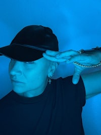 a woman wearing a black hat with a blue background