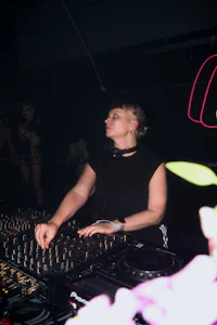 a woman djing in front of a dj booth