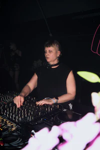 a woman djing in a dark room with flowers