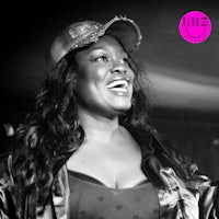 a black and white photo of a woman singing into a microphone